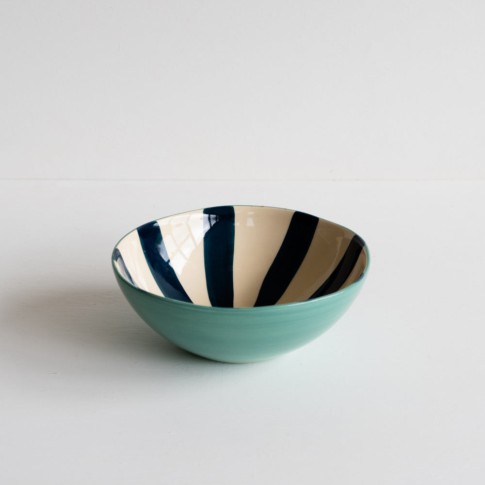 Ceramic bowl with navy candy stripe on the inside and on the outside it's painted turquoise