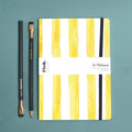 yellow striped notebook against blue backdrop