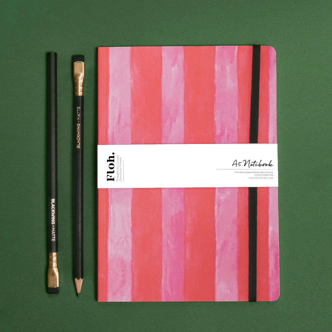 pink striped notebook against green backdrop