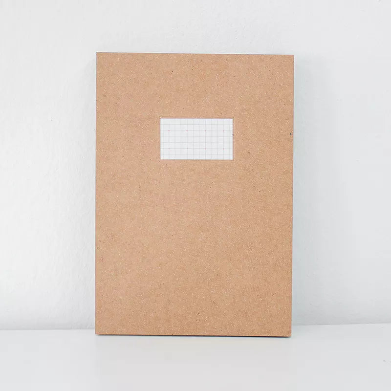Brown notebook with a grid sticker on a white background