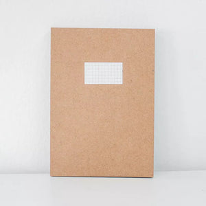 Brown notebook with a grid sticker on a white background