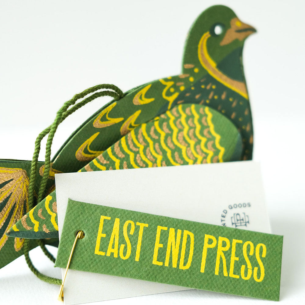 Decorative paper bird with 'East End Press' label on a white background