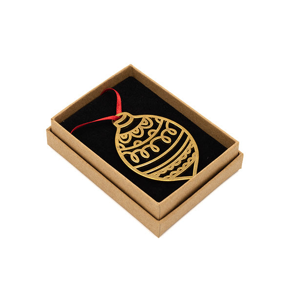 Brass decoration in the shape of a bauble, photographed in a brown box in front of white background.