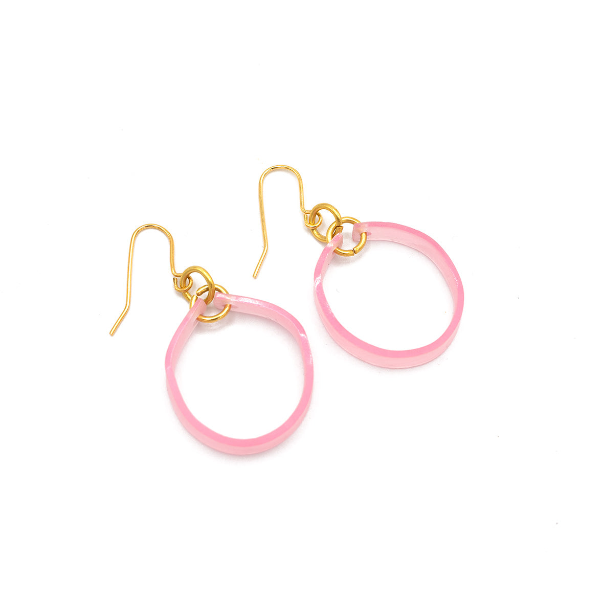 Pink acetate hoop earrings with gold hook fastening - photographed laid flat against a white background