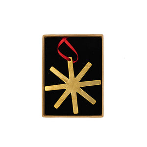 Brass decoration in the shape of a star with red ribbon. Inside a box.
