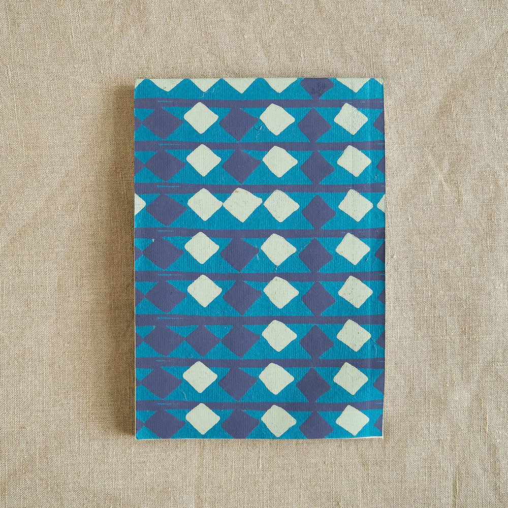 Blue sketchbook with screen-printed repeat pattern of diamonds.