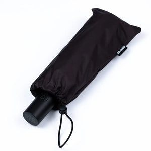Black umbrella folded and tied with a visible brand logo on a white background