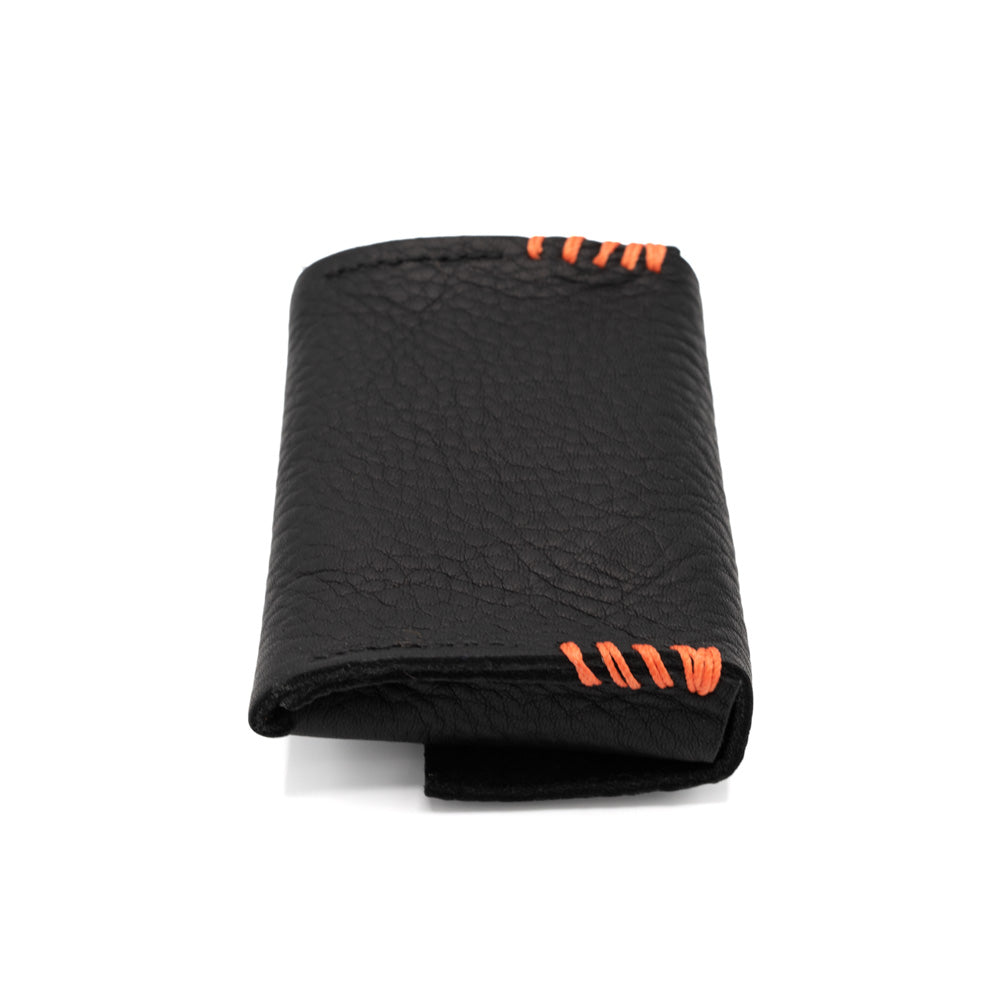 Rectangular black leather purse with stud enclosure and orange stitched detail photographed against a white background.
