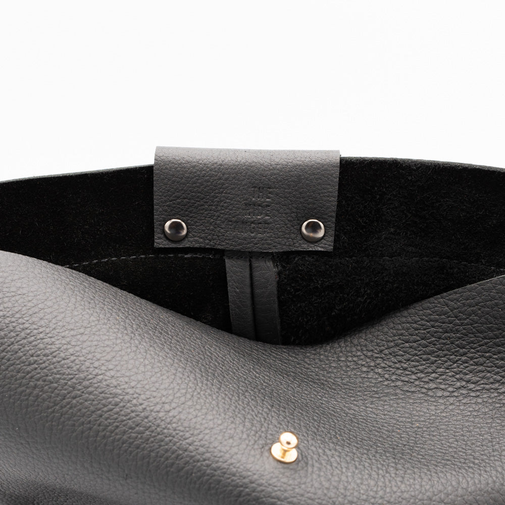 Close up detail of a black leather bucket bag with The Hide Ranger stamped
