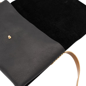Close up of the cross-body black leather bag.