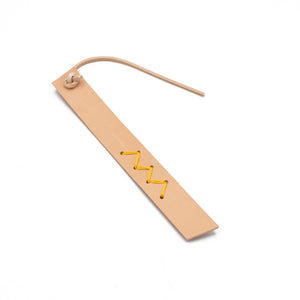 Pale pink leather bookmark with yellow zig-zag stitch detail. White background.