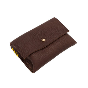 Rectangular brown leather purse with stud enclosure and yellow stitched detail photographed against a white background.