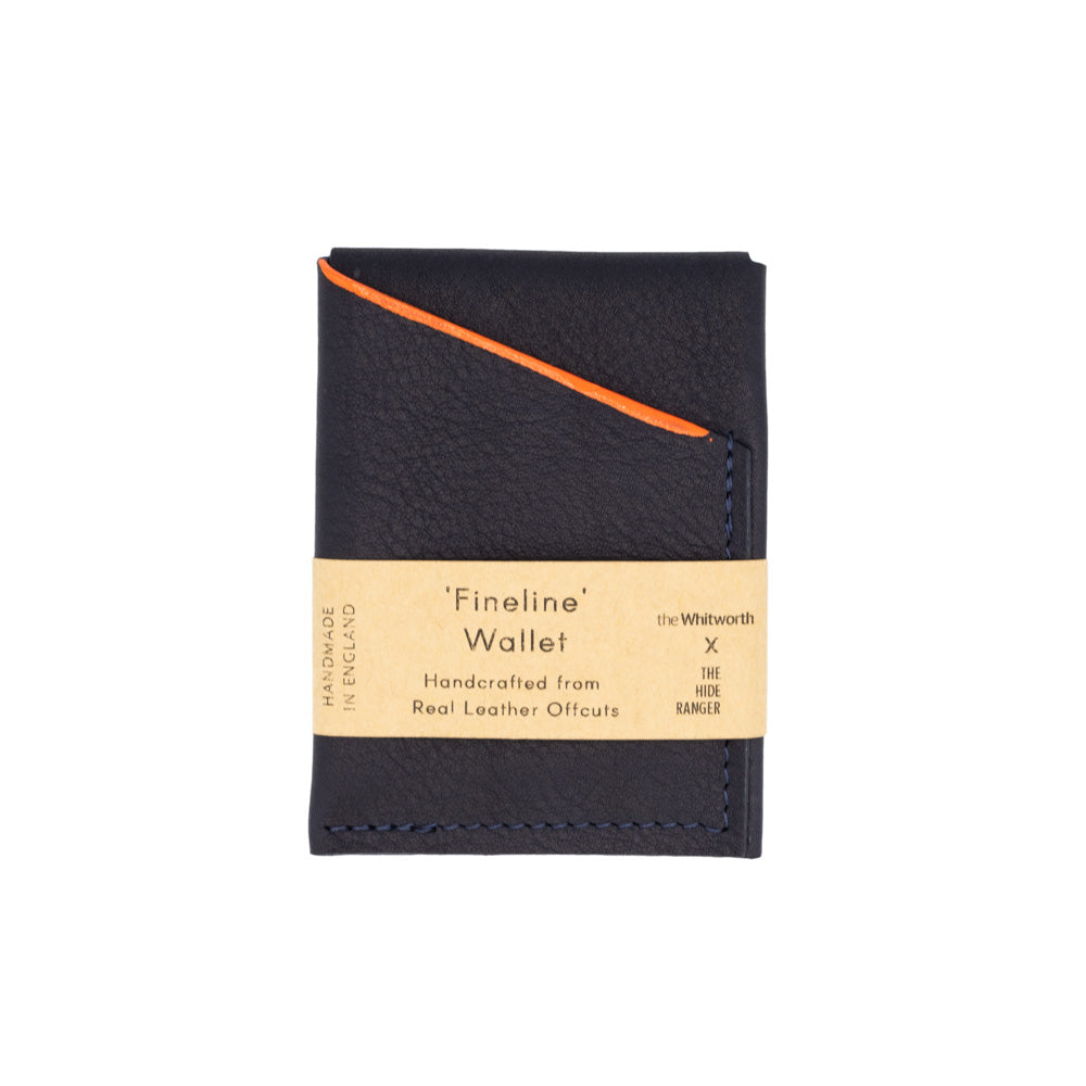 Navy rectangular leather wallet with orange line detail. Brown belly band with product information. Photographed in front of white background.