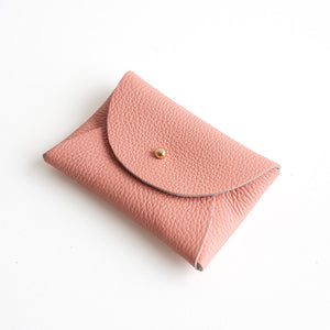 Pink leather purse with a gold clasp on a white background