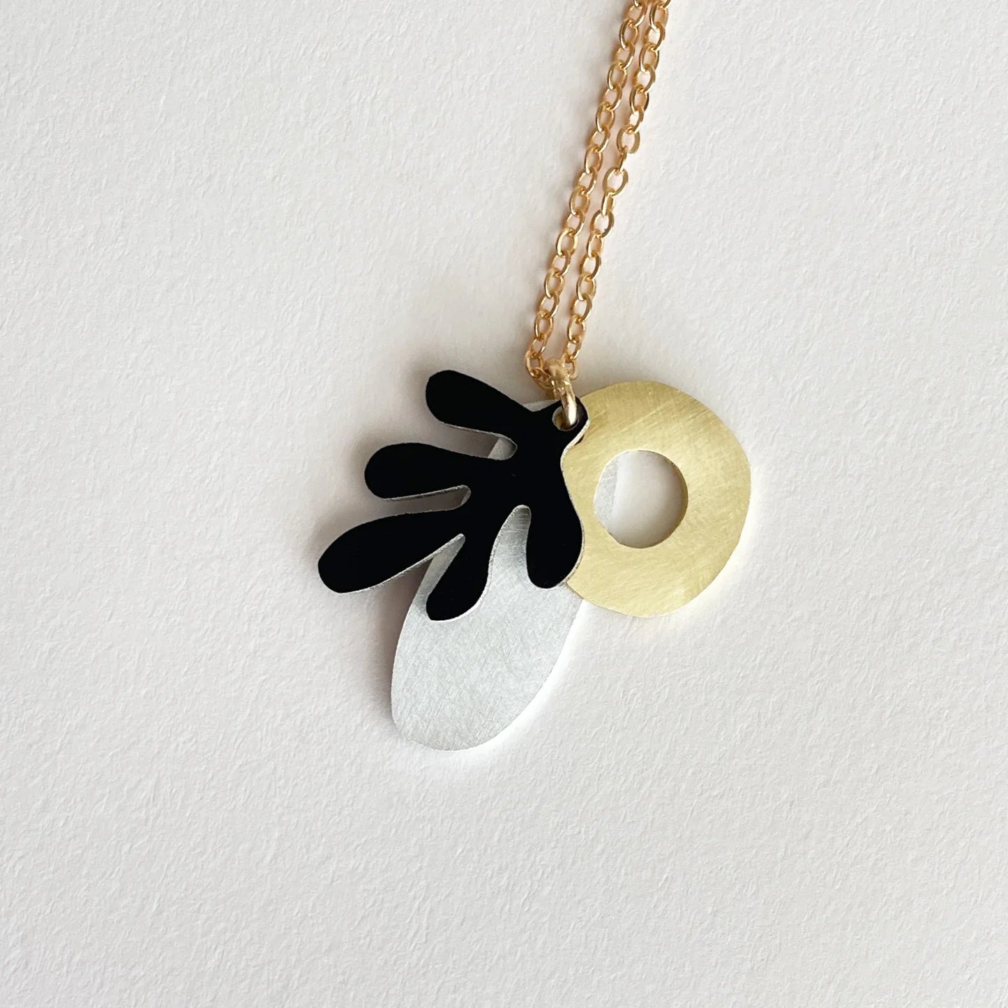 Necklace with three mixed metal shapes.
