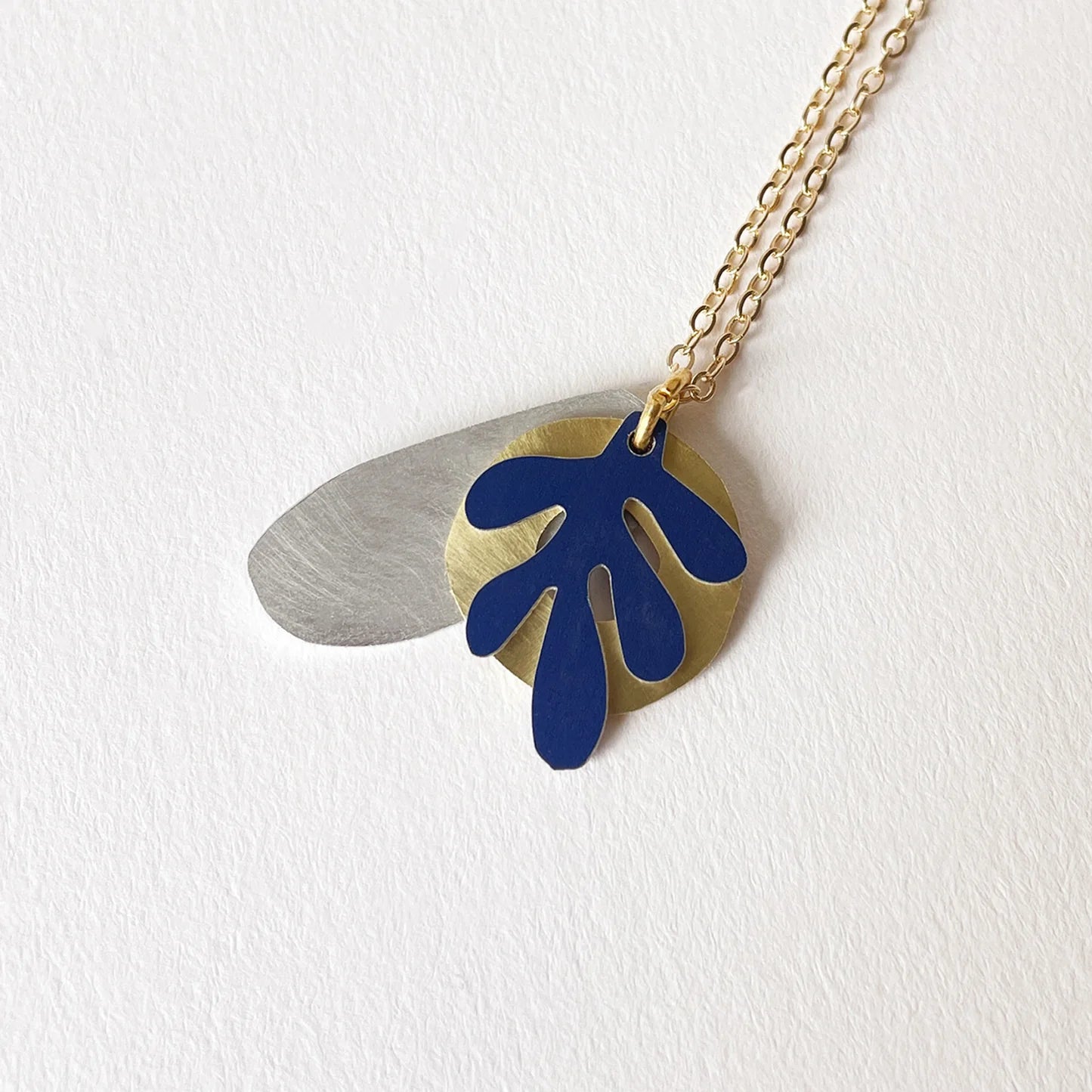 Necklace with three mixed metal shapes.