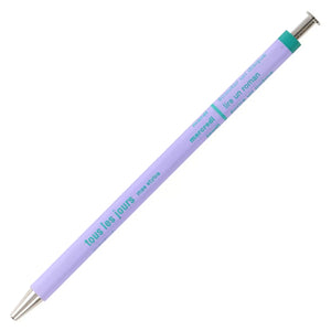 A lilac ballpoint pen with a green cap. The pen has French text printed on it.