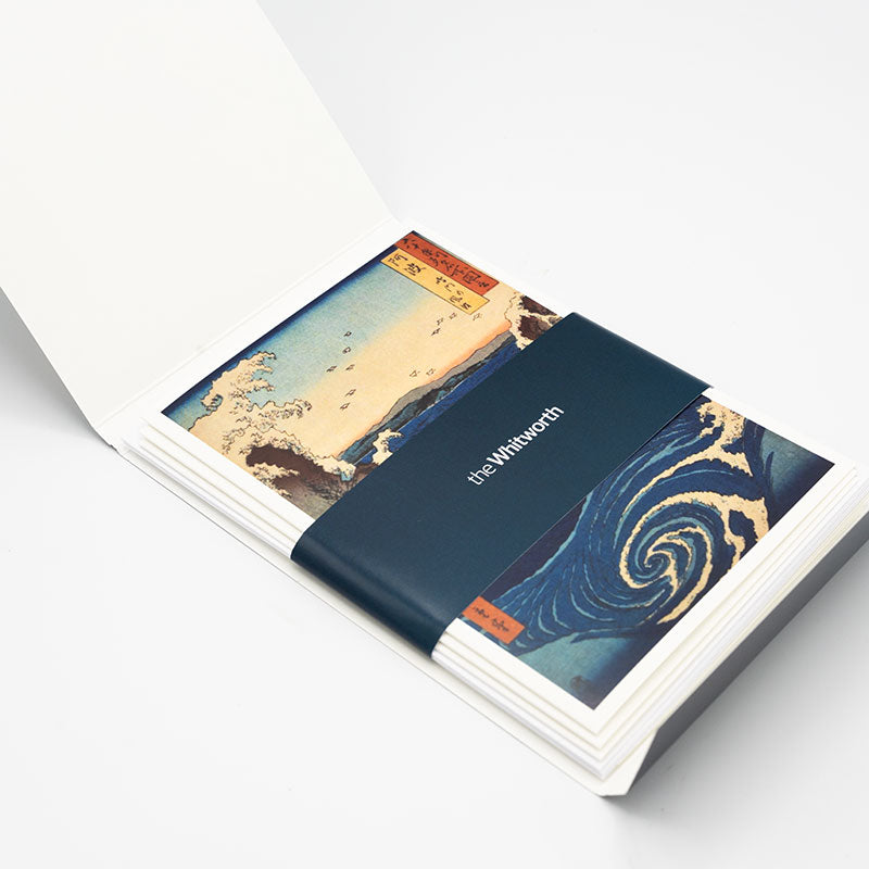 Inside of the greetings card pack with the cards wrapped in a navy Whitworth-branded belly band.
