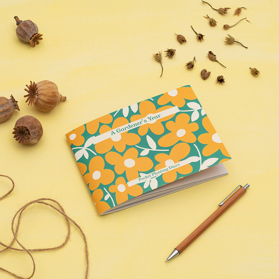 A6 diary with a yellow and green floral print on the front cover, photographed against a yellow background.