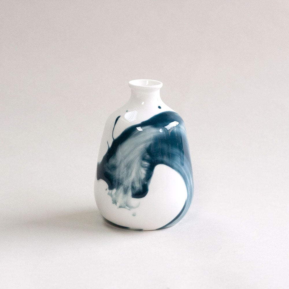 White bottle vase with a blue wash pattern, photographed against a white background