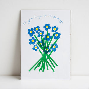 Framed artwork with blue flowers and green stems on a white background