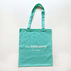 Mint coloured tote bag with Whitworth logo against white background.