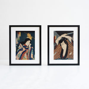 Two Japanese woodcut prints in black frame photographed in front of a white background