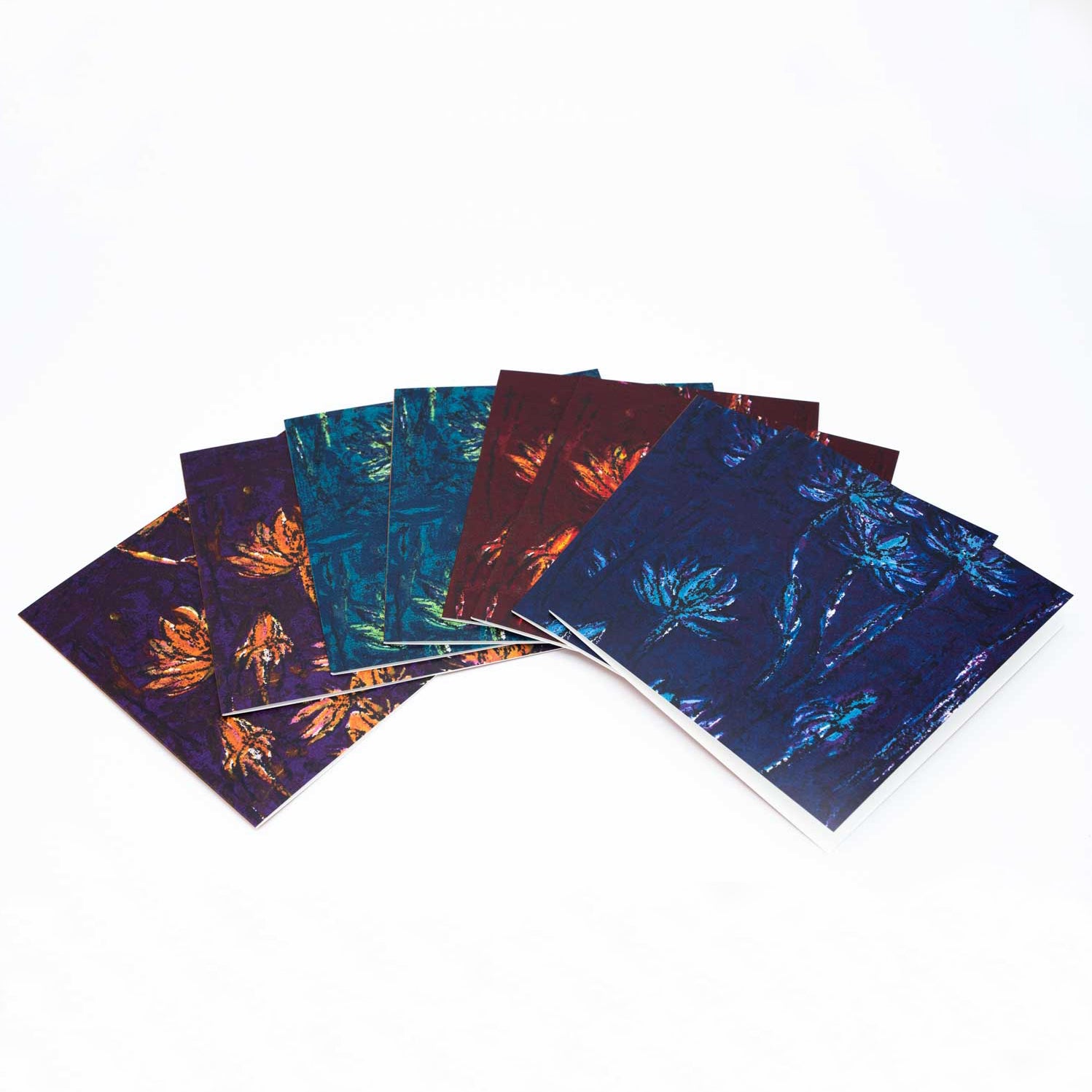 The eight cards placed in a fan shape on a white backdrop. There are two of each colourway artwork. The envelopes are white.
