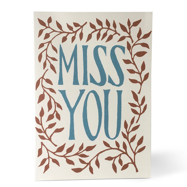 Cream Card with Miss You in blue font at the centre. Floral pattern around the outside.