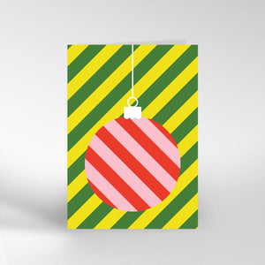 Image of a card. Green and yellow striped background with a pink striped bauble.