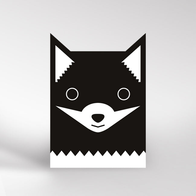 Black and white card with fox ears cutout at the top. The black fox is black white a white muzzle and white at the bottom of the card.