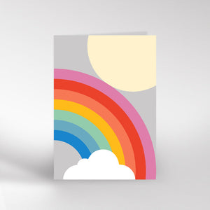 Grey card with a rainbow curving up from the bottom to the middle of the left side. There is a pale yellow sun in the top right corner and a white cloud at the bottom where the rainbow starts.