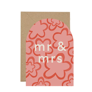 Pink card with brown envelope against white background. The words Mr and Mrs written.
