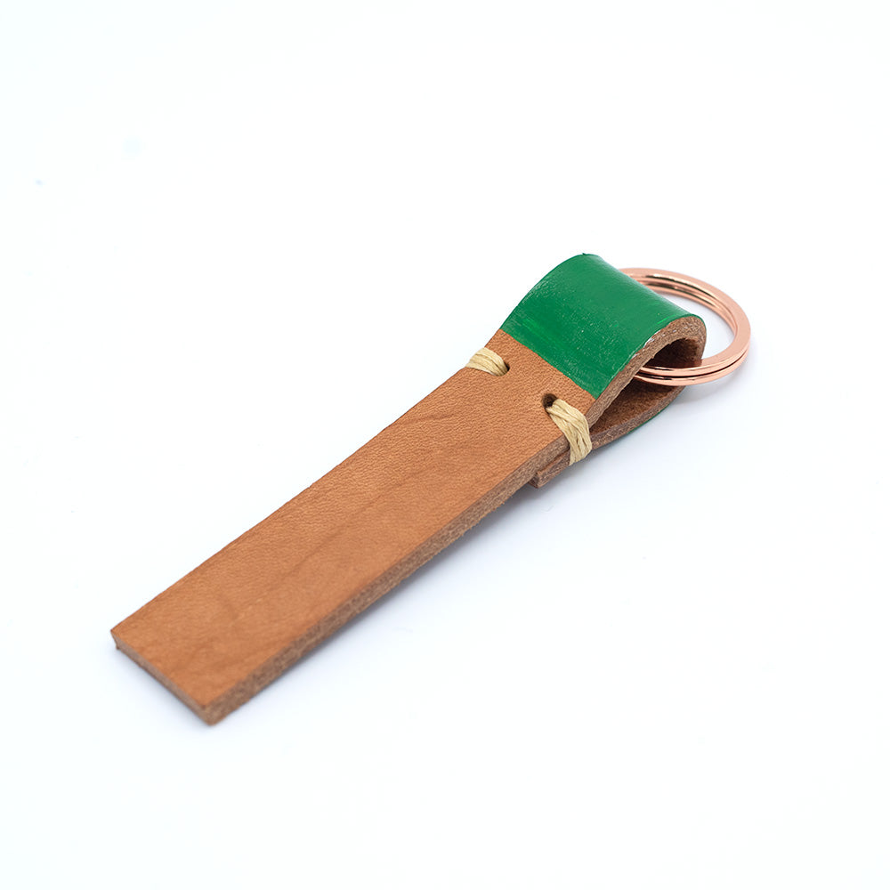 Image of brown leather keyring with green detail against a white background.