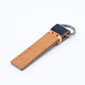 Image of brown leather keyring with navy detail against a white background.