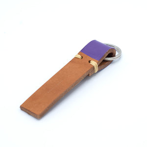 Image of brown leather keyring with purple detail against a white background.