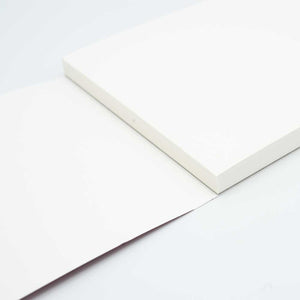 Cropped photo of an open sketchpad against a white background.