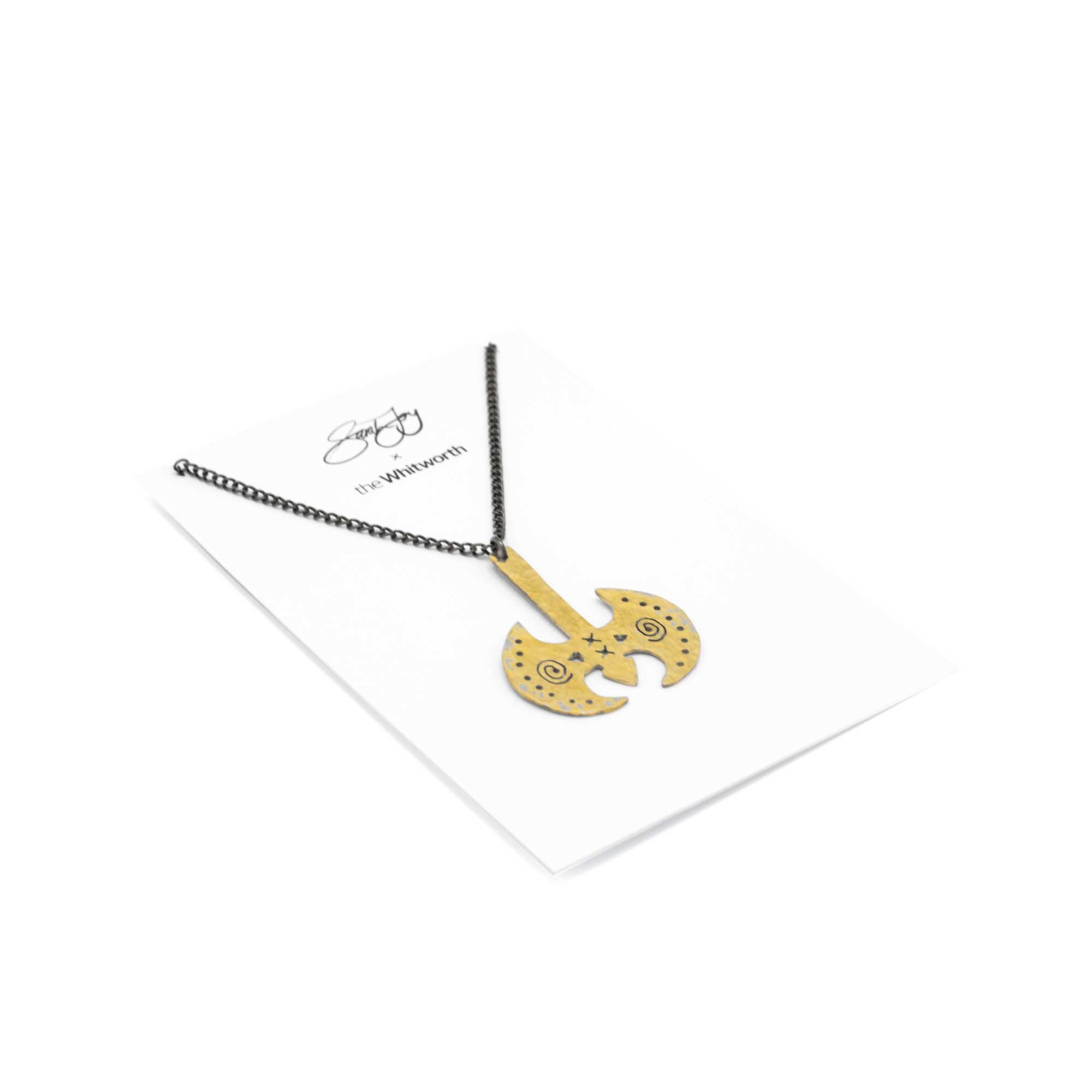 Gold Labrys pendant necklace against a white backdrop. Card backing.