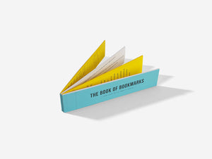 An image against a white background of a a blue book of bookmarks with yellow and white insert pages.