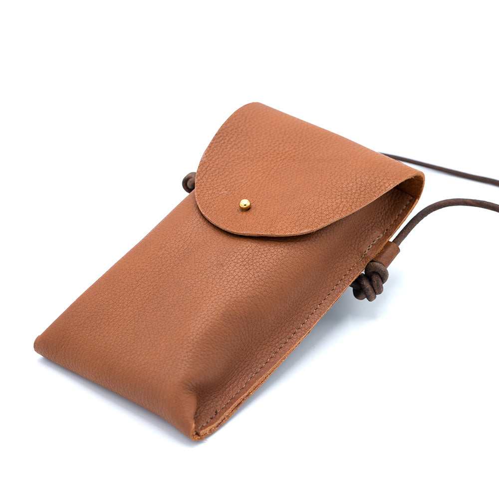 Image of a brown leather rectangular bag against a white backdrop.