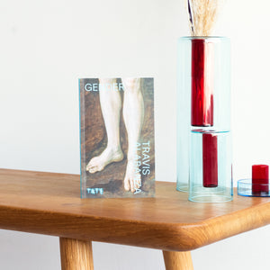 Lifestyle shot if book Look Again: Gender - Travis Albanza with some blue and red glass vases to the side