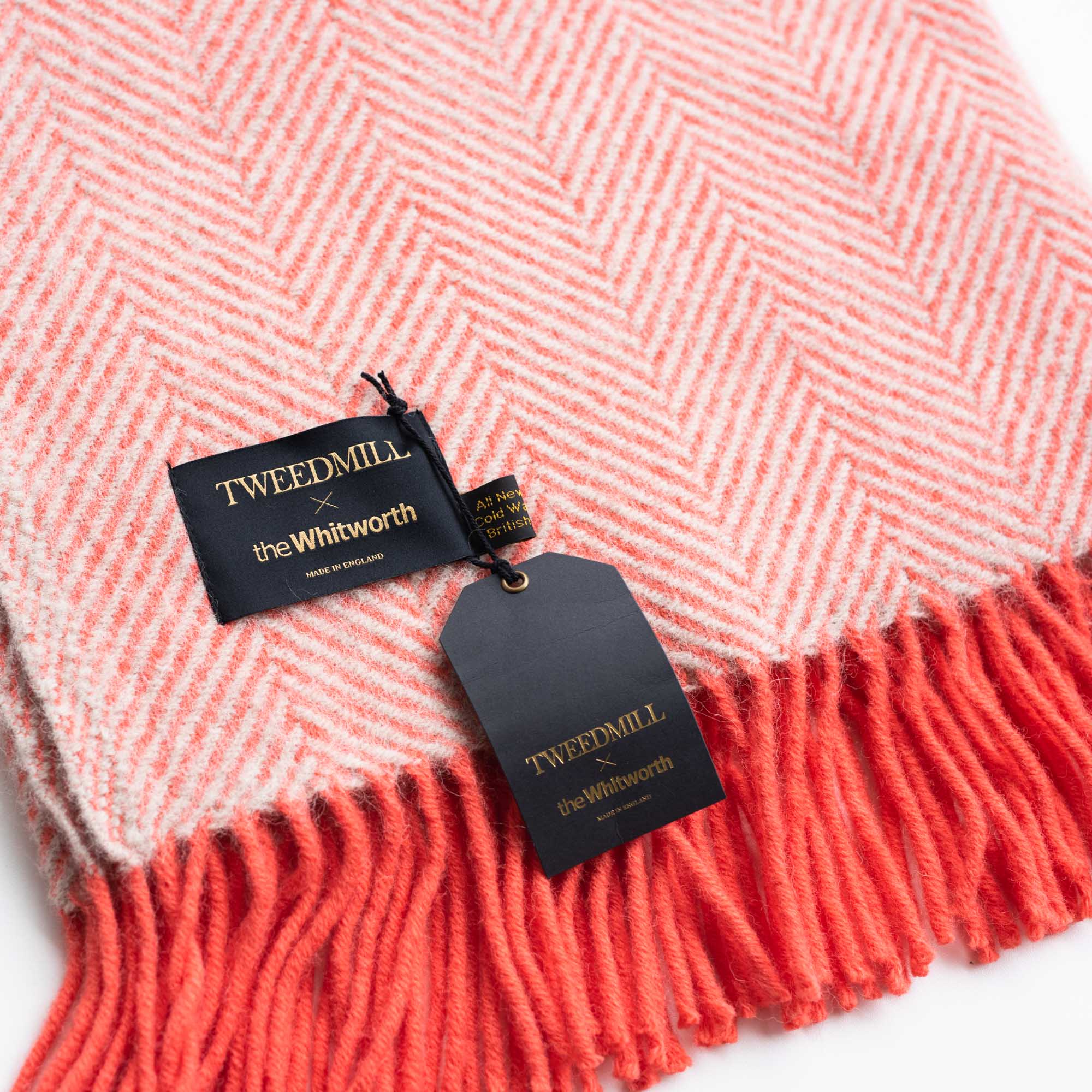 Close up of red woollen blanket with Tweedmill x Whitworth Label