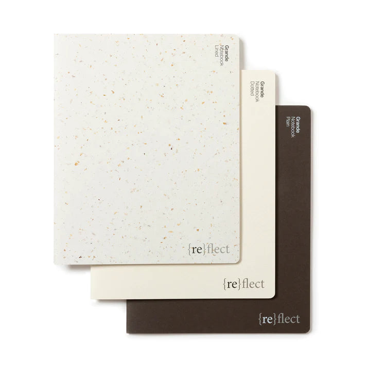 Three notebooks in white, cream and brown laid flat against a white background