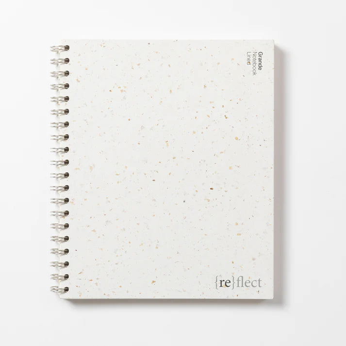 White dotted ring bound notebook against white backdrop