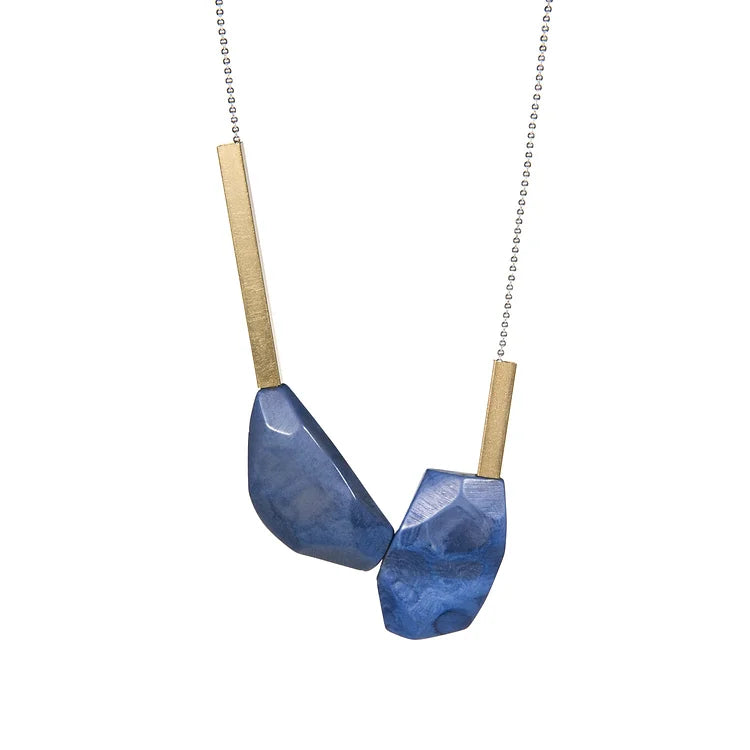 Brass and tagua pendant with two irregularly shaped blue-dyed tagua pieces.