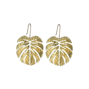 The brass earrings of a monstera leaf shape on a white background.