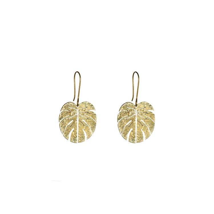 The brass earrings of a monstera leaf shape on a white background.