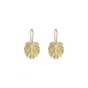 The brass earrings of a monstera leaf shape on a white background.