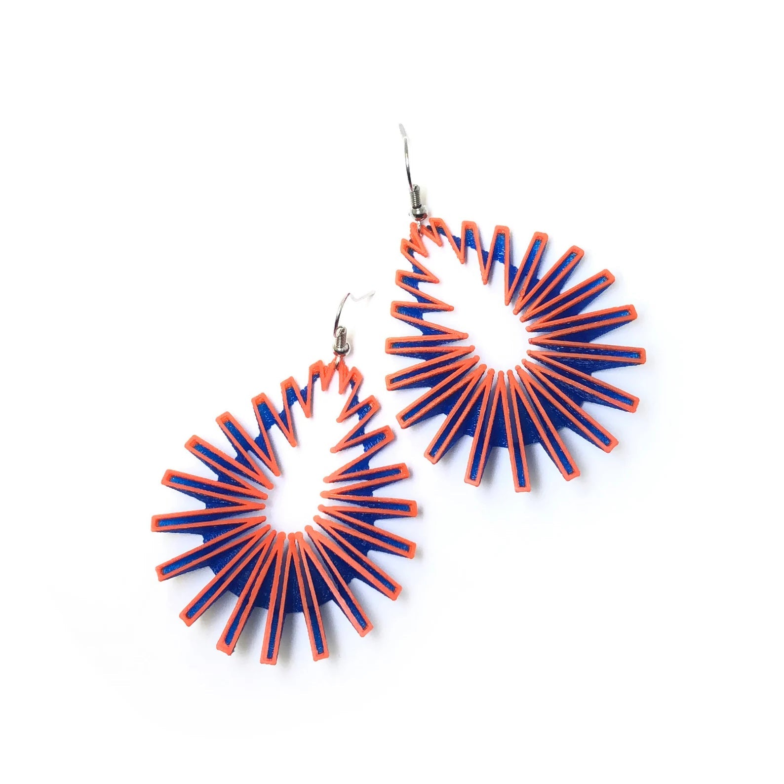 A pair of zigzag 3d printed earrings on white background.